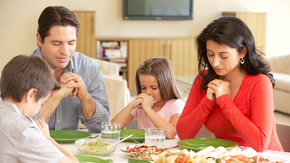 orando en familia en la mesa
